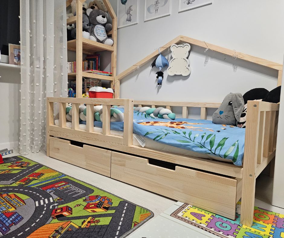 Łóżko domek Alva z barierkami i szufladami w pokoju dziecka
